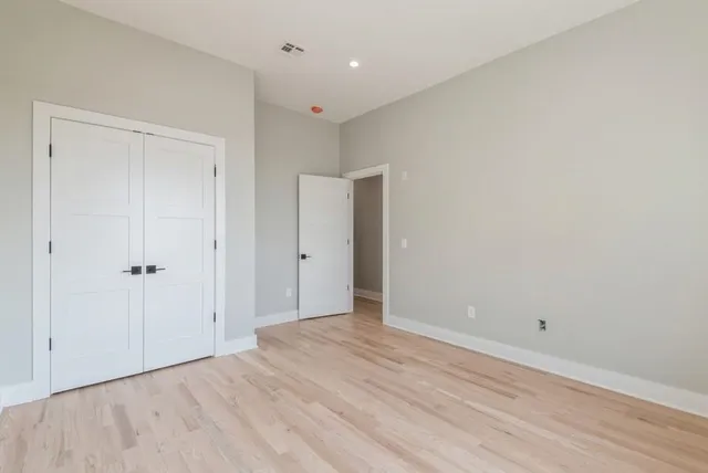 a view of an empty room with wooden floor
