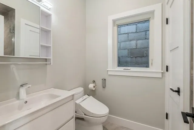 a bathroom with a sink toilet and a mirror