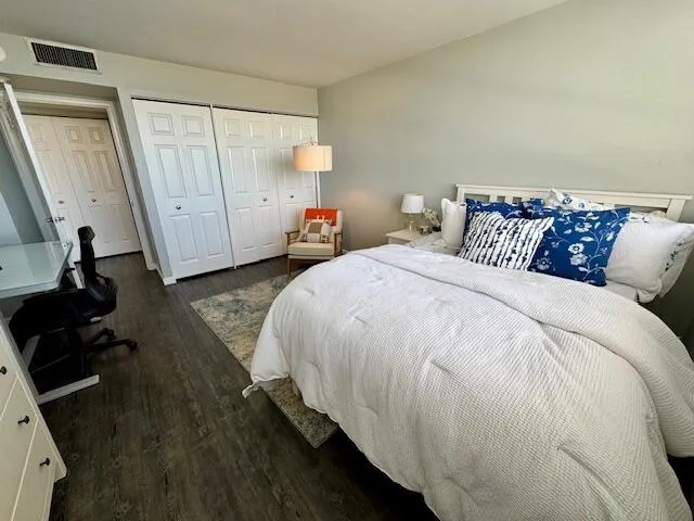 a spacious bedroom with a bed and a black cabinet