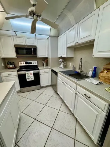 a kitchen with granite countertop a sink stainless steel appliances and cabinets