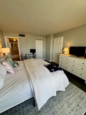 a bedroom with a bed and wooden floor