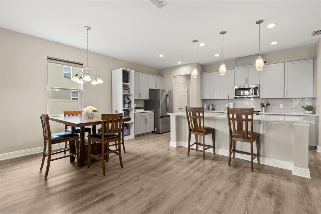 7670 Modica Street Clermont, FL 34714 - Photo 2 of 46 a view of a dining room with furniture and wooden floor