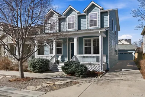 a front view of a house with a yard and potted plants