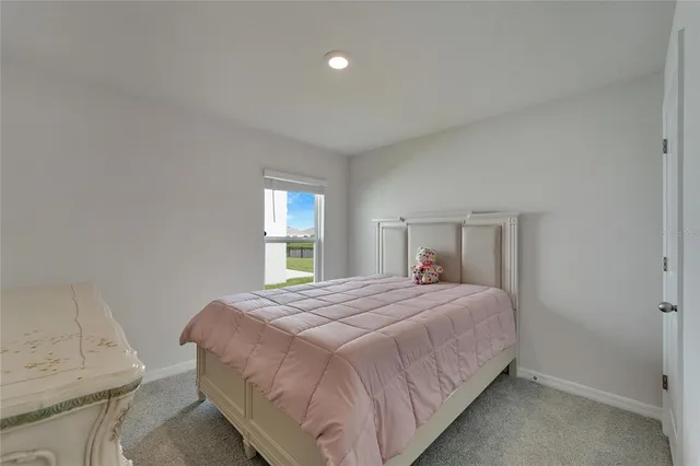 a bedroom with a bed window and mirror