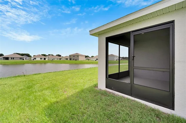 a large white house with a big yard and large trees