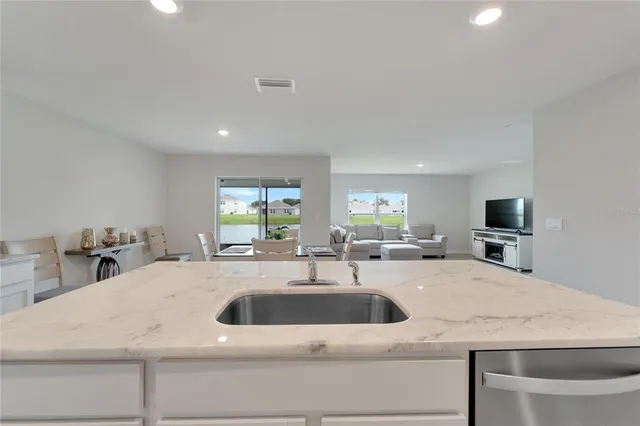 a kitchen with a sink a counter and chairs