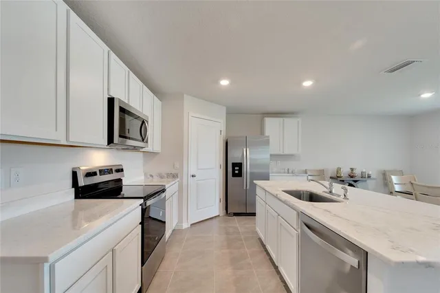 a kitchen that has a lot of cabinets in it and wooden floors