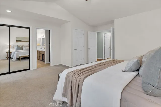 a bedroom with a bed and a large mirror