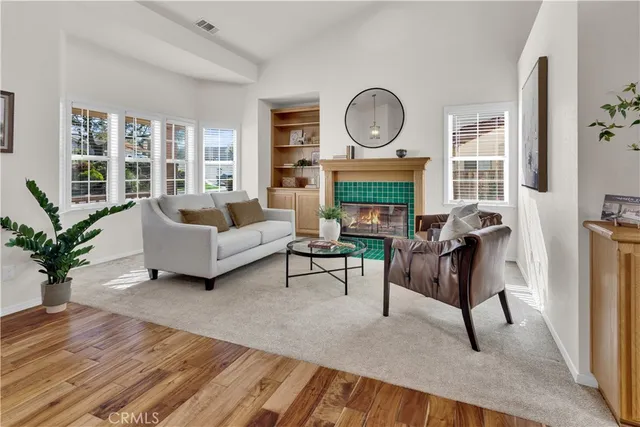 a living room with furniture a fireplace a clock and a large window
