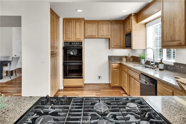 a kitchen with kitchen island granite countertop a sink stove and cabinets