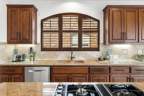 a kitchen with granite countertop a sink and a window