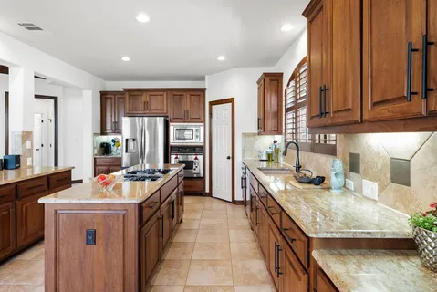 a kitchen with stainless steel appliances granite countertop a stove a sink and a refrigerator