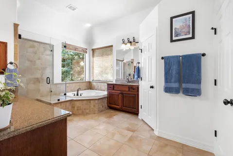 a spacious bathroom with a granite countertop tub sink and mirror