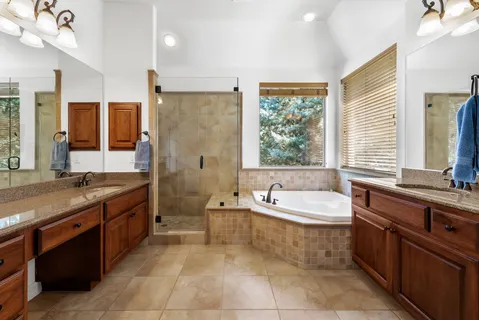 a large bathroom with a double vanity sink large mirror and a bathtub