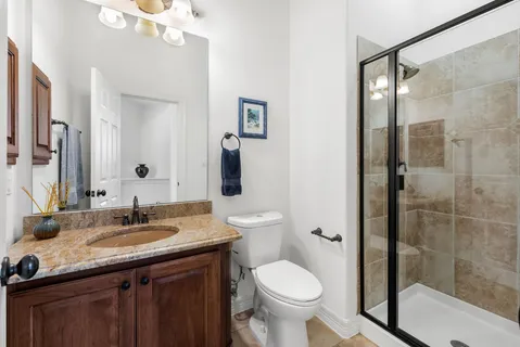 a bathroom with a granite countertop sink toilet and shower