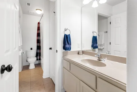 a bathroom with a sink and mirror with toilet