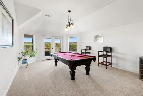 a room with furniture pool table and windows