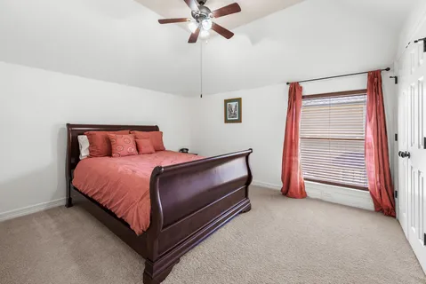 a bedroom with a bed and a ceiling fan