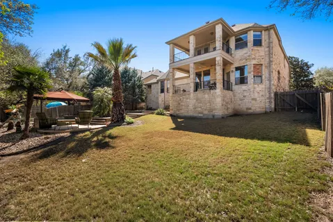 a view of a white house with a yard next to a road