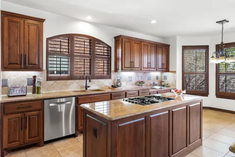 a kitchen with stainless steel appliances granite countertop a stove sink and cabinets