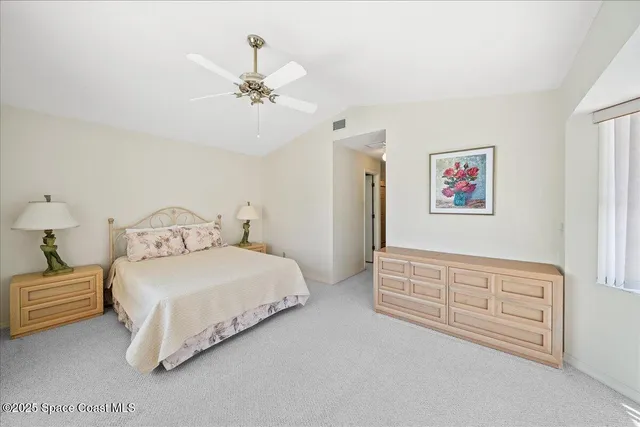a spacious bedroom with a bed and a chandelier