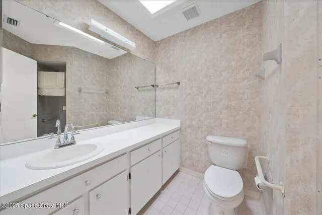 a bathroom with a toilet sink a mirror and vanity