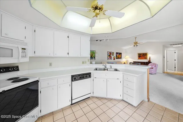 a kitchen with white cabinets and appliances