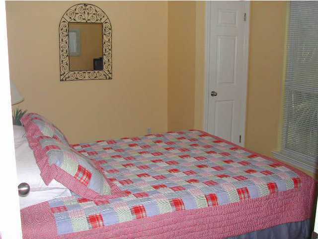 Nantucket Cottage, Unit 6 Destin, FL 32541 - Photo 6 of 10 a bedroom with a bed and a painting on the wall