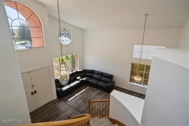 a large living room with stainless steel appliances wooden floor and a large window
