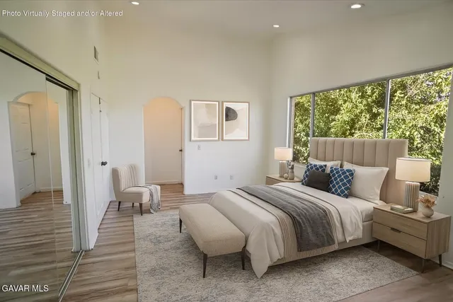 a bedroom with bed and a large window