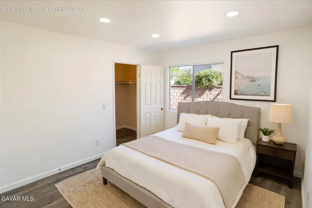 a bedroom with a bed and a painting on the wall