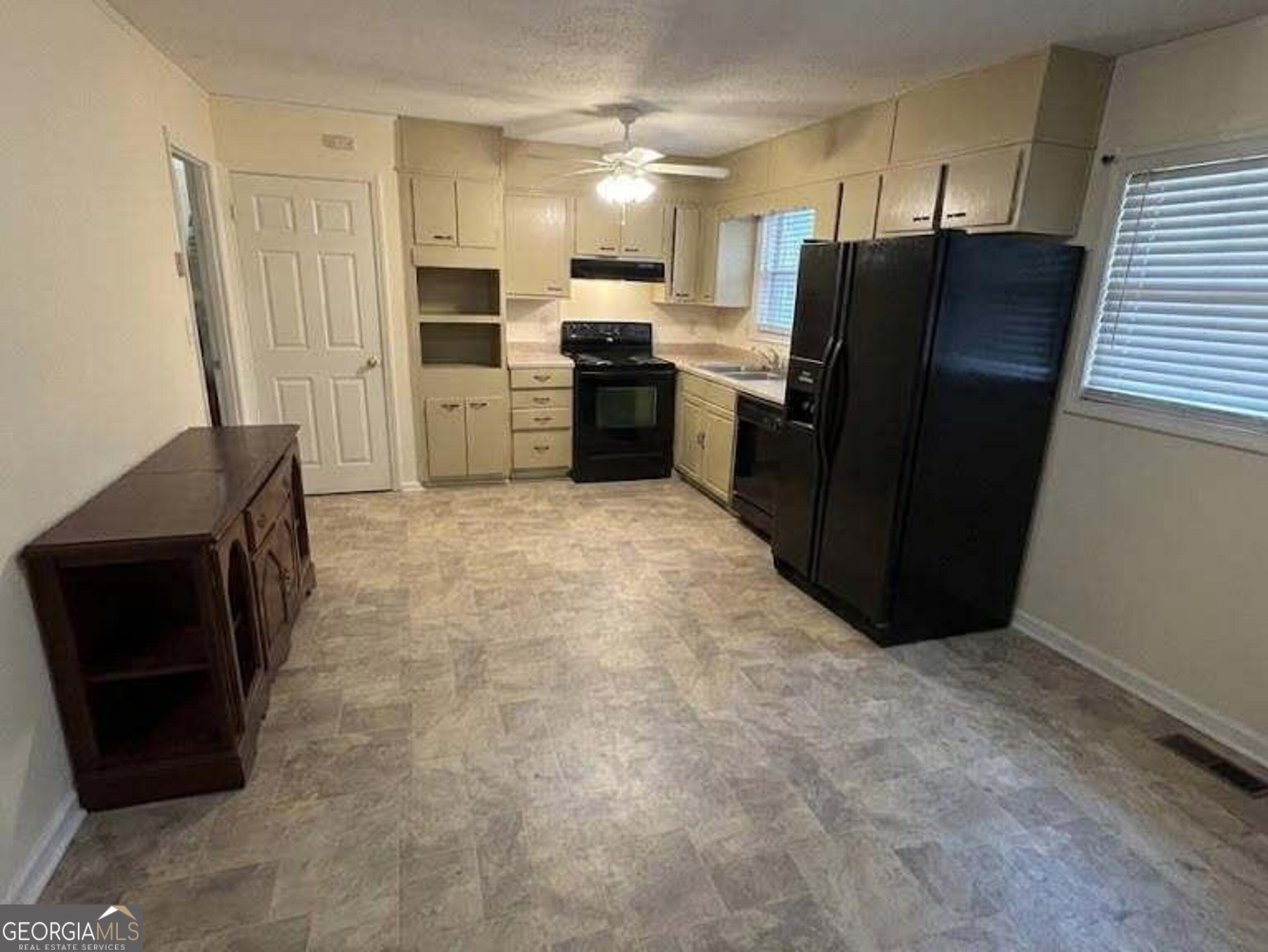 6052 Pinecreek Road Forest Park, GA 30297 - Photo 2 of 12 a kitchen with granite countertop a refrigerator and a stove top oven