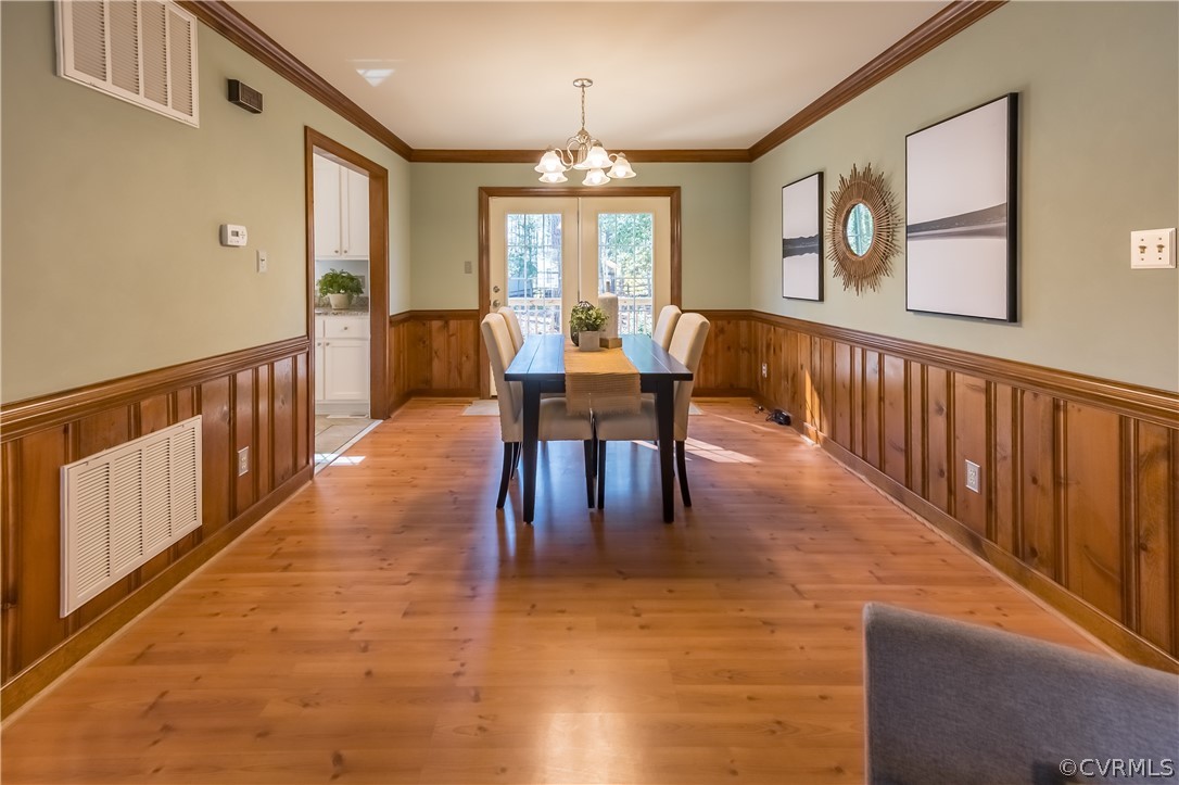 5012 Rollingway Road Chesterfield, VA 23832 - Photo 17 of 35 a dining room with wooden floor a chandelier a glass table and chairs
