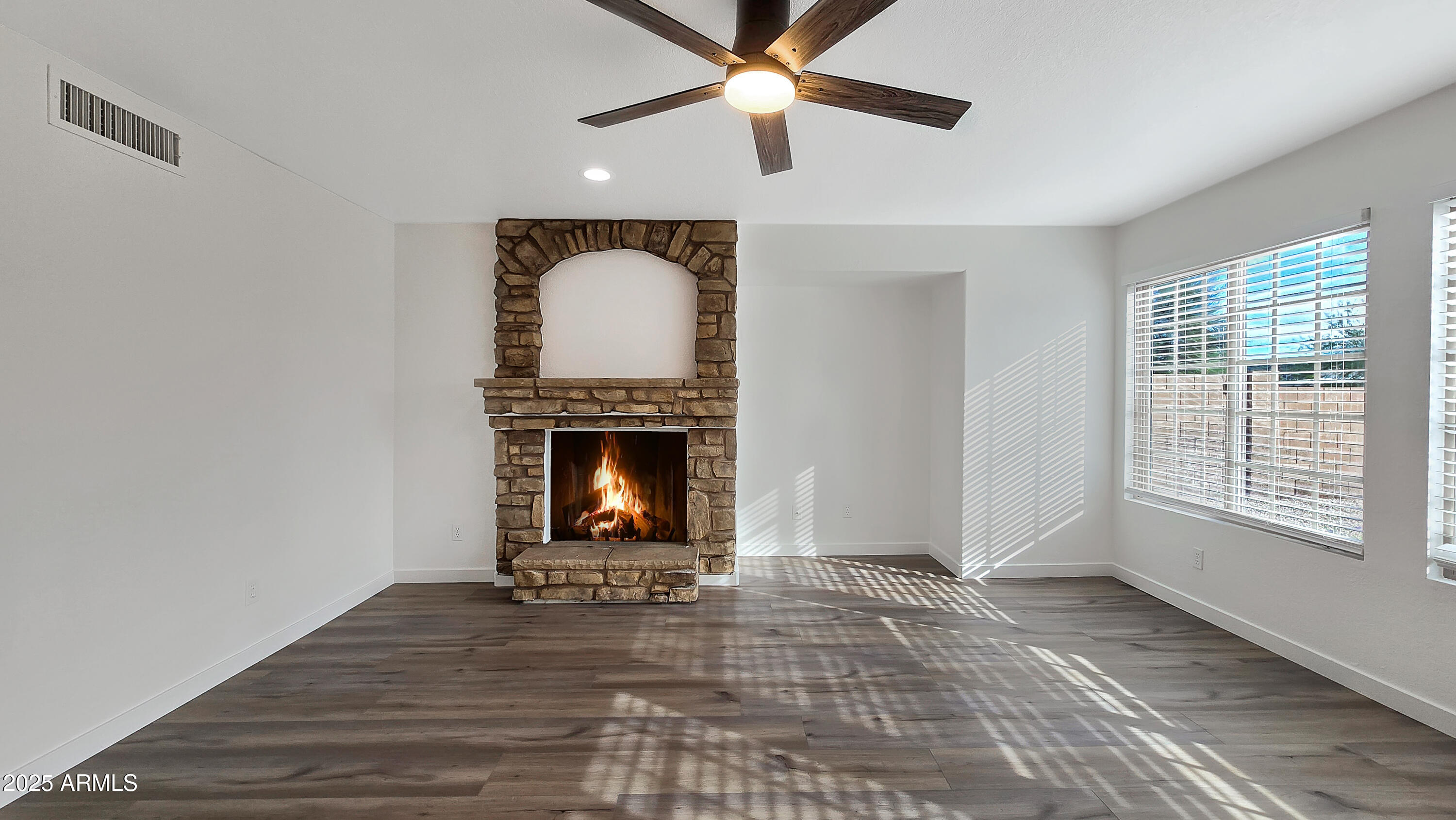 2119 West Tracy Lane Phoenix, AZ 85023 - Photo 11 of 31 a view of an empty room with wooden floor fireplace and a window
