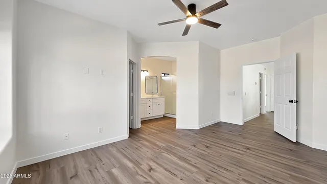 an empty room with wooden floor a ceiling fan and closet