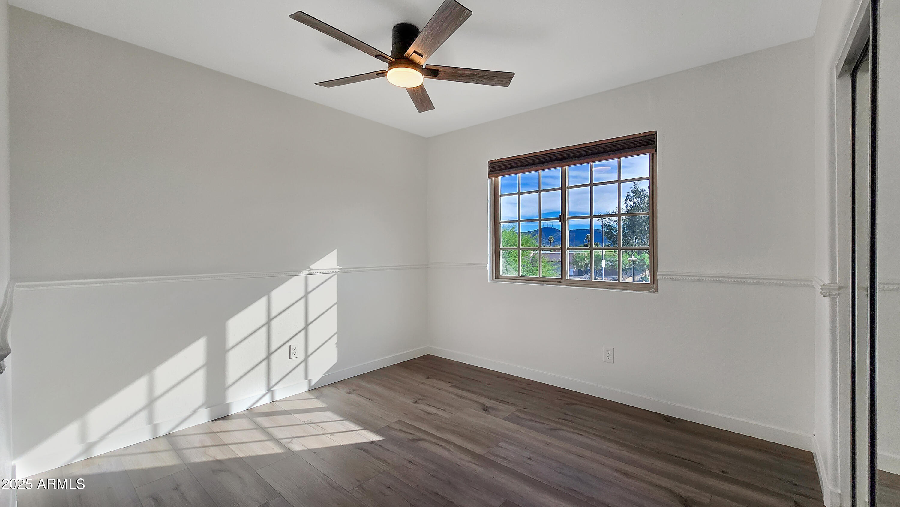2119 West Tracy Lane Phoenix, AZ 85023 - Photo 19 of 31 a view of empty room with wooden floor and fan