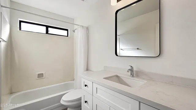 a bathroom with a granite countertop toilet a sink and a mirror