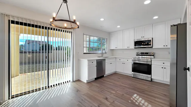 a kitchen with granite countertop a stove a sink and a refrigerator