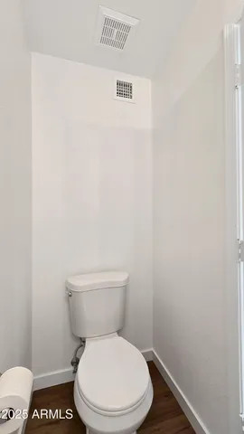 a white toilet sitting next to a white wall