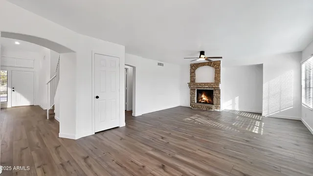 a view of empty room with wooden floor and fireplace