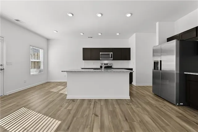 a view of kitchen with microwave refrigerator and cabinets