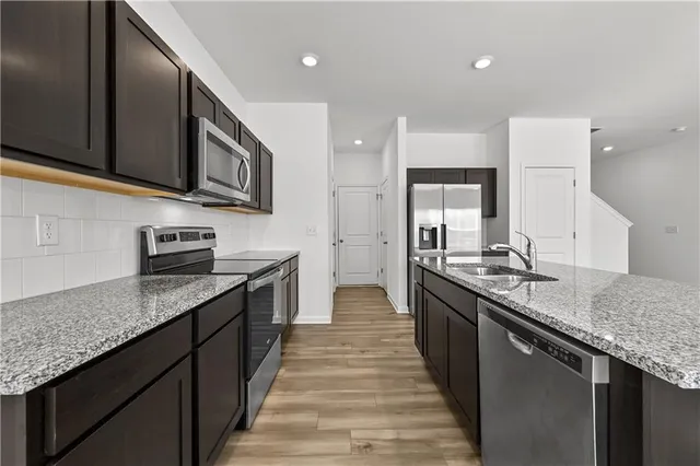 a kitchen with stainless steel appliances granite countertop a sink and a stove