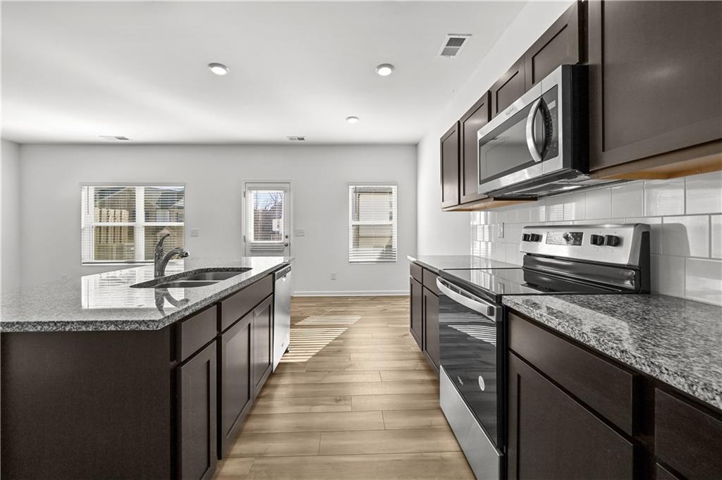 1102 Lossie Lane Grayson, GA 30017 - Photo 15 of 34 a kitchen with stainless steel appliances granite countertop a sink and stove top oven