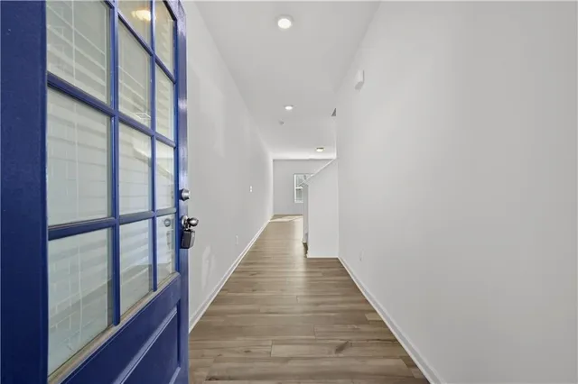 a view of a hallway with wooden floor and staircase