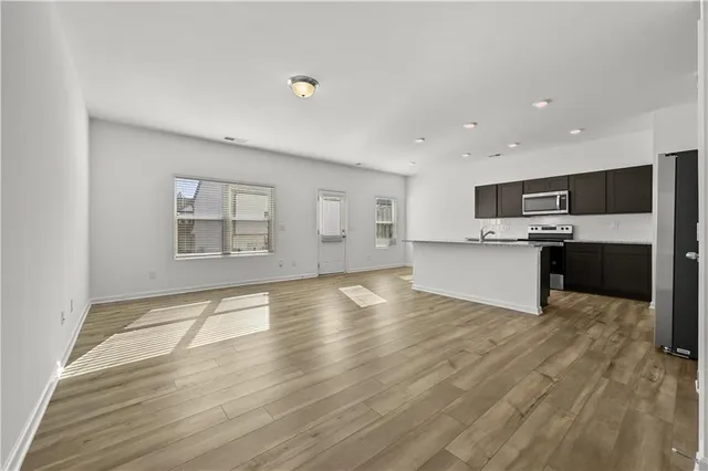 a view of a kitchen with a sink stove cabinets and empty room