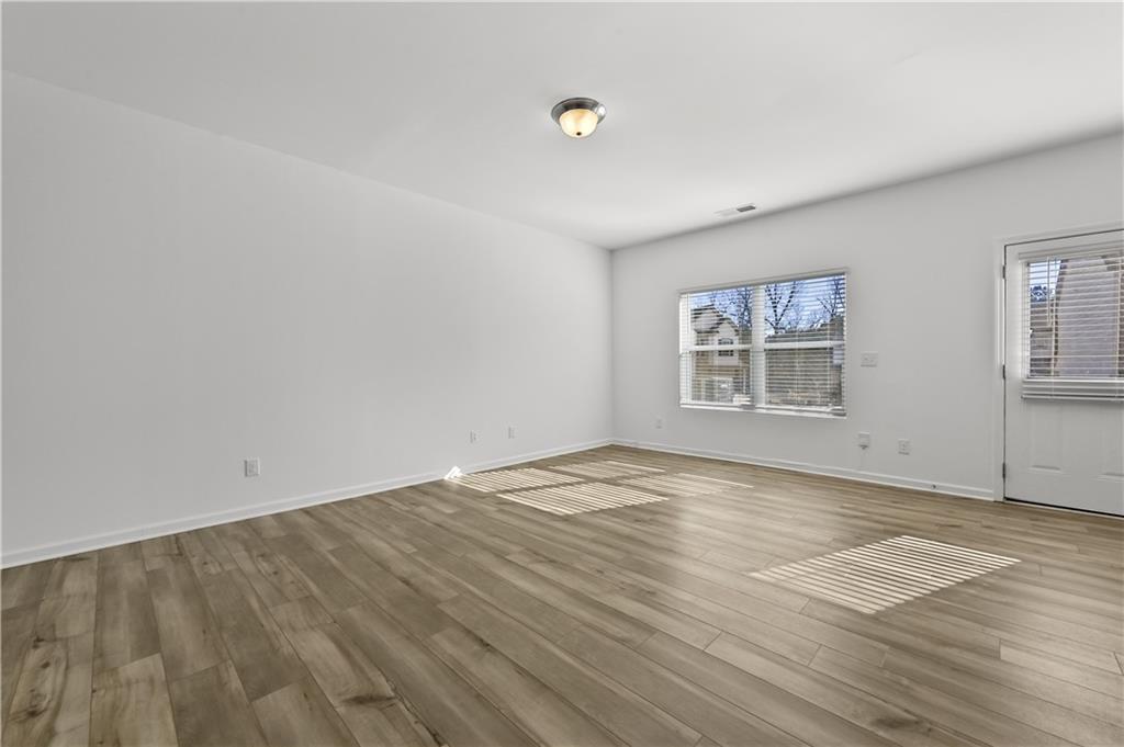 1102 Lossie Lane Grayson, GA 30017 - Photo 8 of 34 an empty room with wooden floor and windows