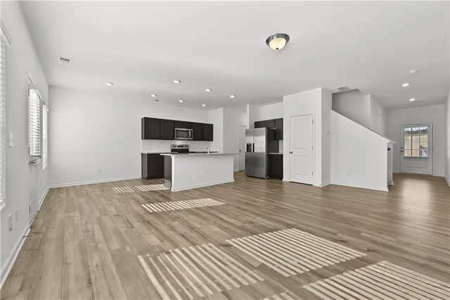 a view of a kitchen with a sink stove cabinets and empty room