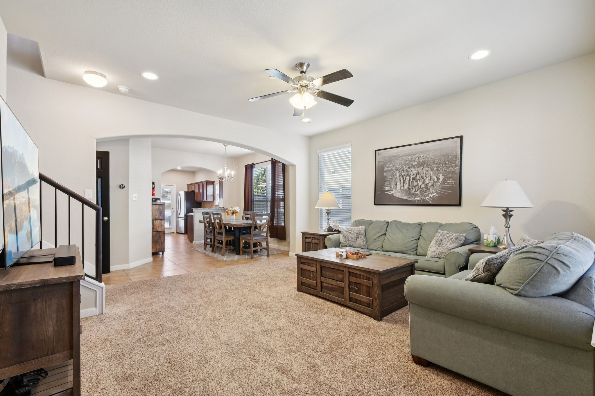 616 Lookout Tree Lane Round Rock, TX 78664 - Photo 4 of 39 Living area featuring arched walkways, light colored carpet, ceiling fan, suspended lighting, and light tile patterned flooring