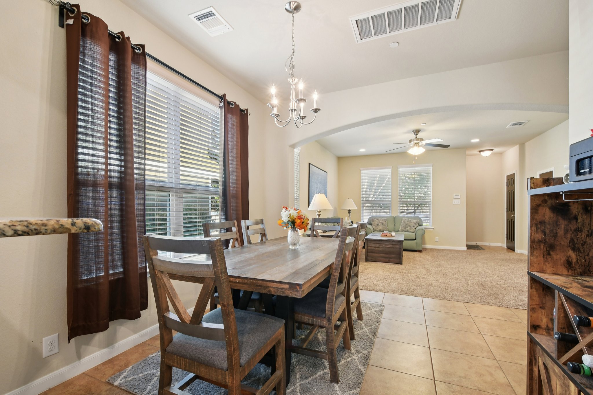 616 Lookout Tree Lane Round Rock, TX 78664 - Photo 5 of 39 Dining area with arched walkways, light tile patterned floors, a ceiling fan, a chandelier, and light carpet
