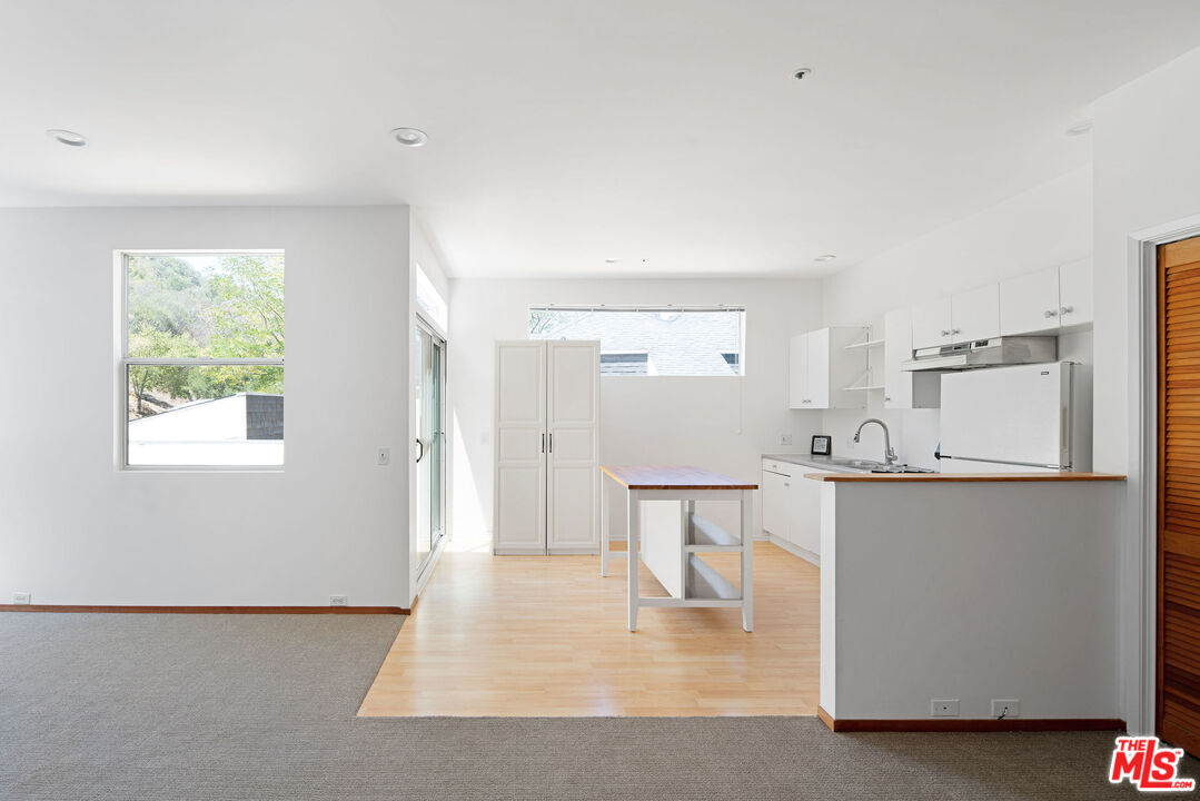 25830 Piuma Road Calabasas, CA 91302 - Photo 26 of 34 a kitchen with white cabinets and wooden floor